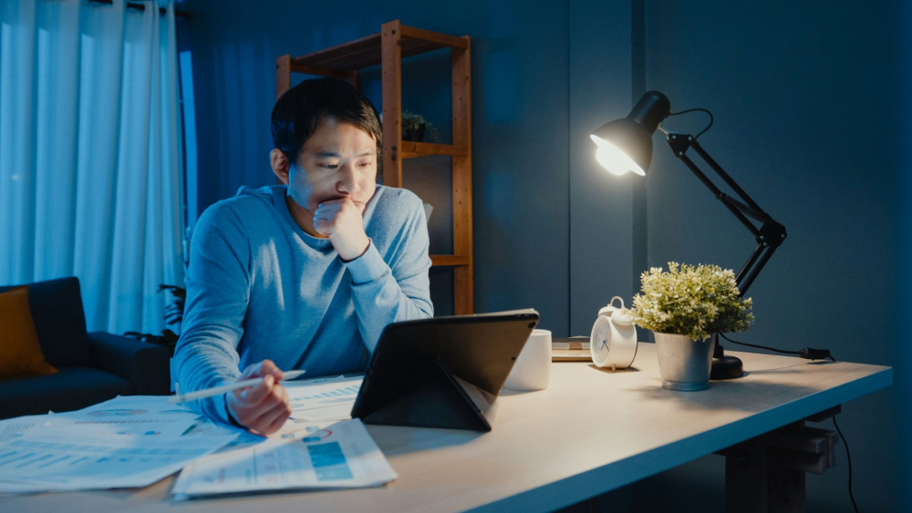 Psychologist reviewing a draft autism diagnostic evaluation report late in the evening